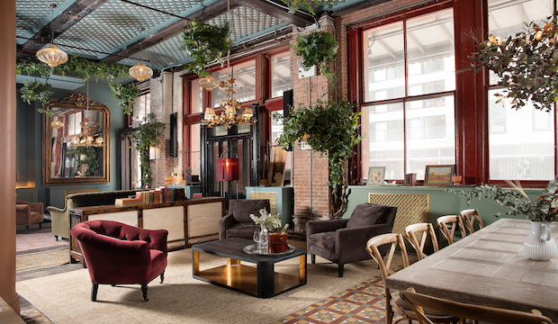 The Garden Room – A Stunning Light-Filled Oasis at Maxwell Social A bright and stylish lounge at Maxwell Social, featuring large windows, lush greenery, exposed brick, and elegant seating for a refined yet relaxed atmosphere