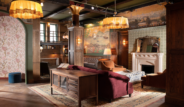 The Explorer’s Room – Luxurious and Timeless Elegance at Maxwell Social A sophisticated lounge at Maxwell Social with rich wood interiors, plush seating, vintage artwork, and warm ambient lighting for an intimate and luxurious atmosphere