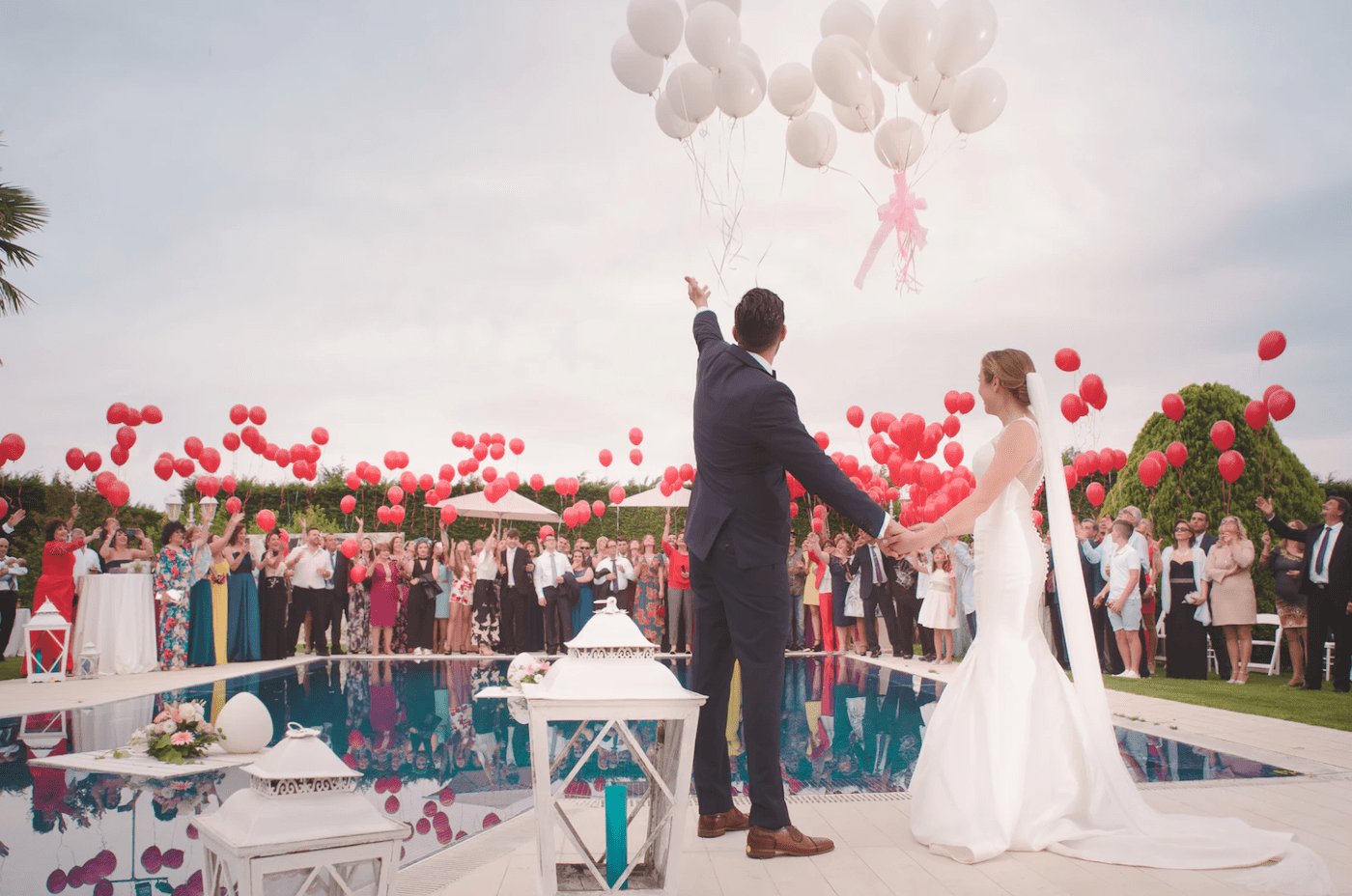 A bride and groom throwing balloons at their wedding